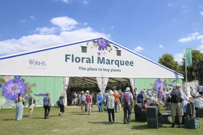 cilvēki, kas apmeklē milzīgo ziedu telti Rhs Hampton Court Palace dārza festivālā, kas agrāk bija Hemptonkortas ziedu izstāde