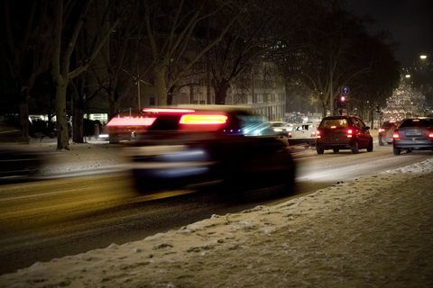 Naktī uz sniega klāta iela, satiksme - neskaidra kustība