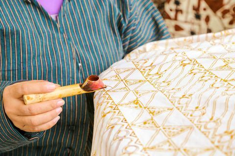 sievietes vidusdaļa izgatavo batiku uz tekstila