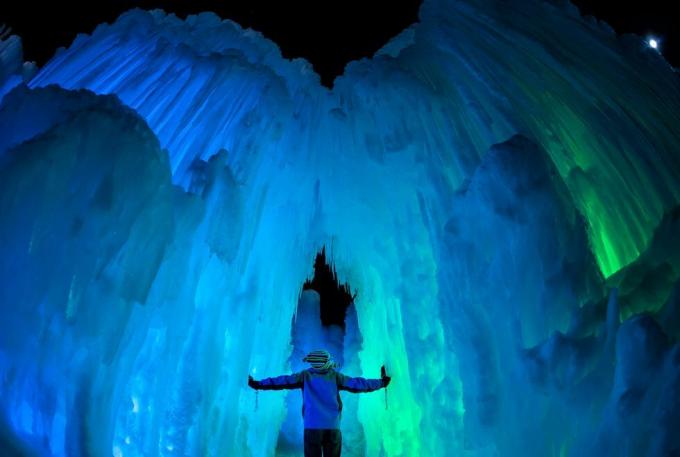 cilvēks, kas stāv lielā ledus alā