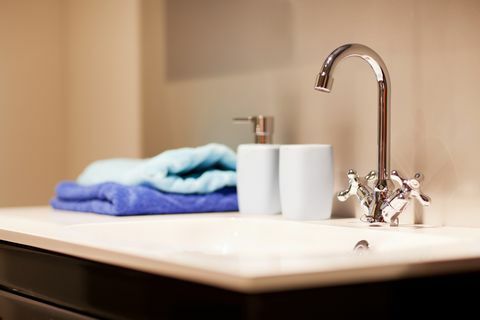 vannas istabas izlietne ar hromētu jaucējkrānu un dvieļiem
