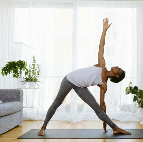 Sieviete, kas praktizē jogu mājās