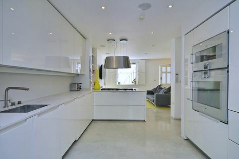 Mūsdienīga balta virtuve ar spīdīgiem skapjiem