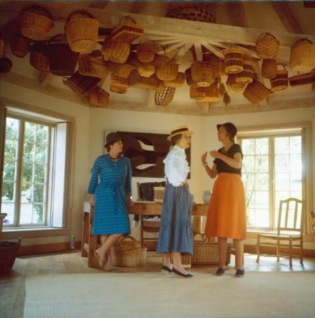 trīs sievietes istabā ar groziem pie griestiem
