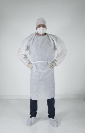 vīrietis, stāvot medicīniskajā aprīkojumā virs drēbēm