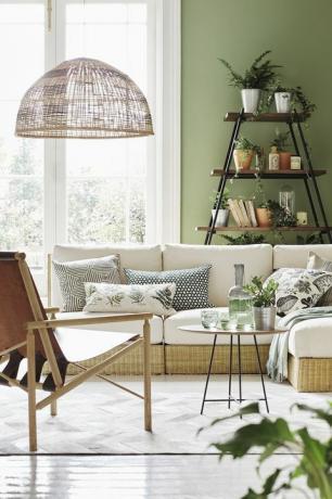 zems balts dīvāns ar izkaisītiem zaļu un baltu rakstu spilveniem baltā telpā ar lielām franču durvīm, koka plauktiem ar melna metāla stabiem, turot brūnus un sudraba podi ar zaļajiem augiem, grāmatas un rotājumi, kā arī brūns izvelkams krēsls zem lielas, austas abažūru sienas, kas nokrāsotas jabridža zaļā īpašuma emulsijā, par 3950 mārciņām 25 l, Farrow bumbiņu rotāta rotangpalmas sēdekļi ar spilveniem, 295 £ katrs Bowen rotangpalmas otoman ar spilvenu, 195 £ visu dzīvotņu atpūtas krēsls, £ 895 alburni galds, £ 462 indah slēpt segums, £ 835 all heal’s line plaukts, £ 550, graham un green rotangpalmas tonis, £ 70, habitaton dīvāns l r kulgam greywhite spilvena pārvalks, £ 49, luma botāniķa izšūts spilvens, £ 14, sainsberijas haveli spilvena pārvalks, 49 mārciņas, Luma syssan spilvens, 12 mārciņas, ikea linu līnijas spilvens, 1999 mārciņa, zara mājas alpakas maisījuma metiens, 90 mārciņas, Northlight homestore uz kafijas galdiņa glāzes, 8 mārciņas katra tekilas krūze, 70 sterliņu mārciņas visi uz augšu plauktu podos, 21 mārciņa par trim, Rockett St George otrajā plaukta podā, no 1 mārciņas, dobbies vintage pudeles, atrodiet līdzīgas mājās kūts ingefära augu pods, no 150 mārciņām par 105 cm diametru, ikea mantojuma aukla, 350 mārciņas, papīra kastes trešā plaukta zeķu augu pods, no 95 p par 105 cm dia, ikea mākslīgā brieža galvaskauss kupolā 69 mārciņas, Rockett St George